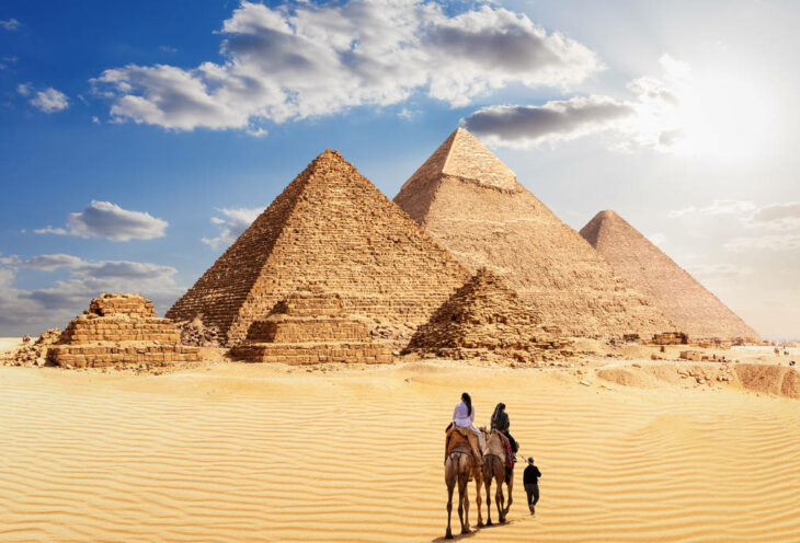 The Great Pyramids of Giza and the bedouins under the desert sun, Egypt.
