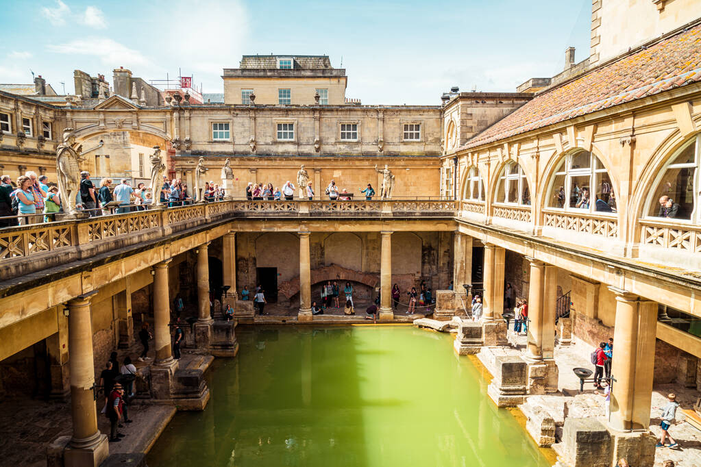 BATH, ENGLAND - AUG 30, 2019 : Roman Baths, the UNESCO World Heritage site with people, which is a site of historical interest in the city of Bath, United Kingdom.