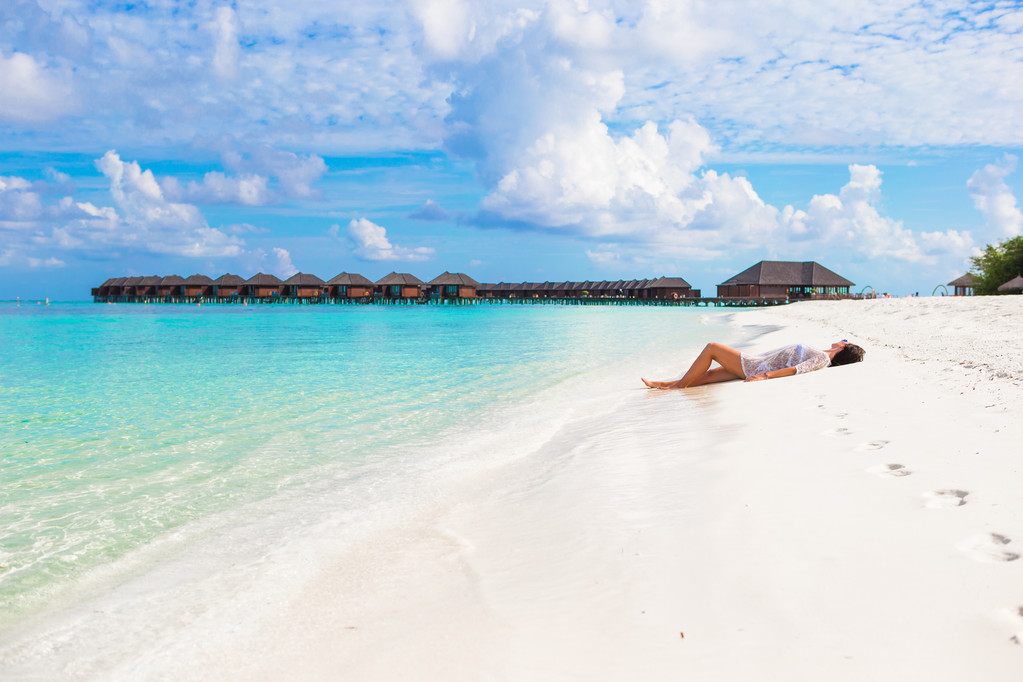 Young beautiful woman relaxing at white sand tropical beach