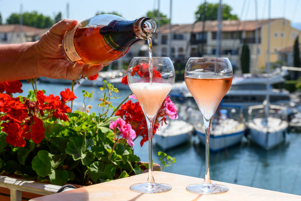 Summer party, drinking of French brut rose champagne sparkling wine in glasses in yacht harbour of Port Grimaud near Saint-Tropez, French Riviera vacation, Var, France