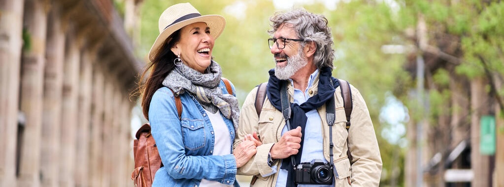 Happy older couple having fun walking outdoors in city. Retired people enjoying a sightseeing walk.
